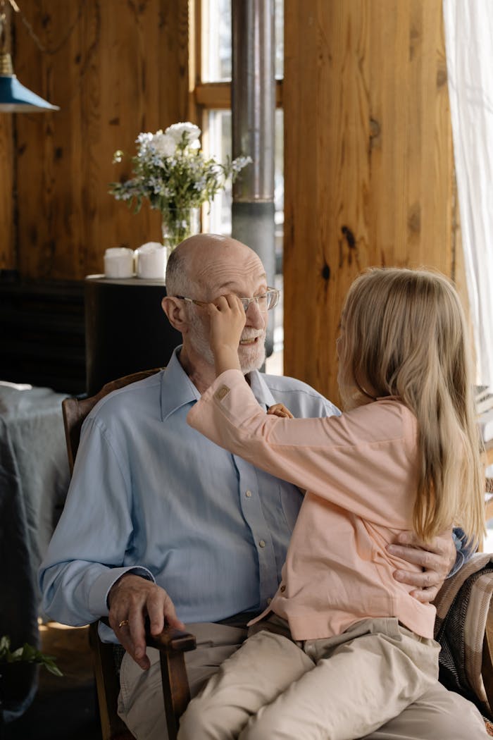 A heartwarming moment between a grandfather and granddaughter bonding at home.
